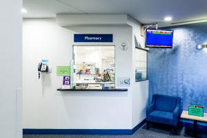 A long shot of the pharmacy window and desk inside a Mercy Health facility.