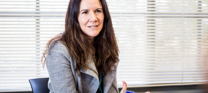 Close up of a woman holding a pen and clipboard, explaining something.